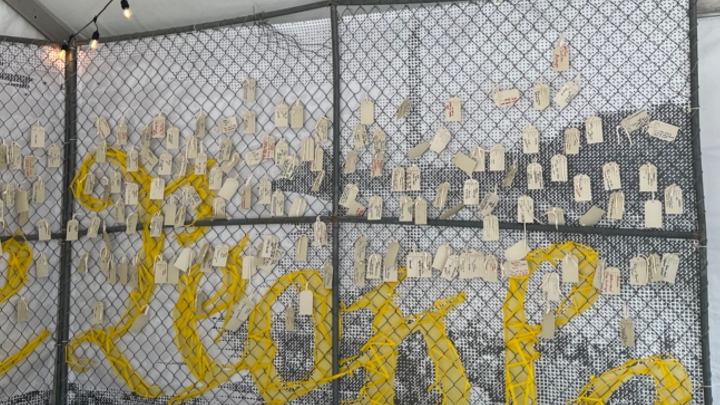 Tags hanging on a chainlink fence -"YOURSto LOSE," exhibit by Freedom Forum at SXSW2024
